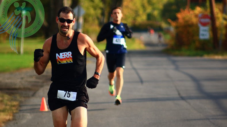 Steve Esposito drives to the OctoberFast 5K finish in Endicott, NY—intense race face—another runner right on his heels at the line.