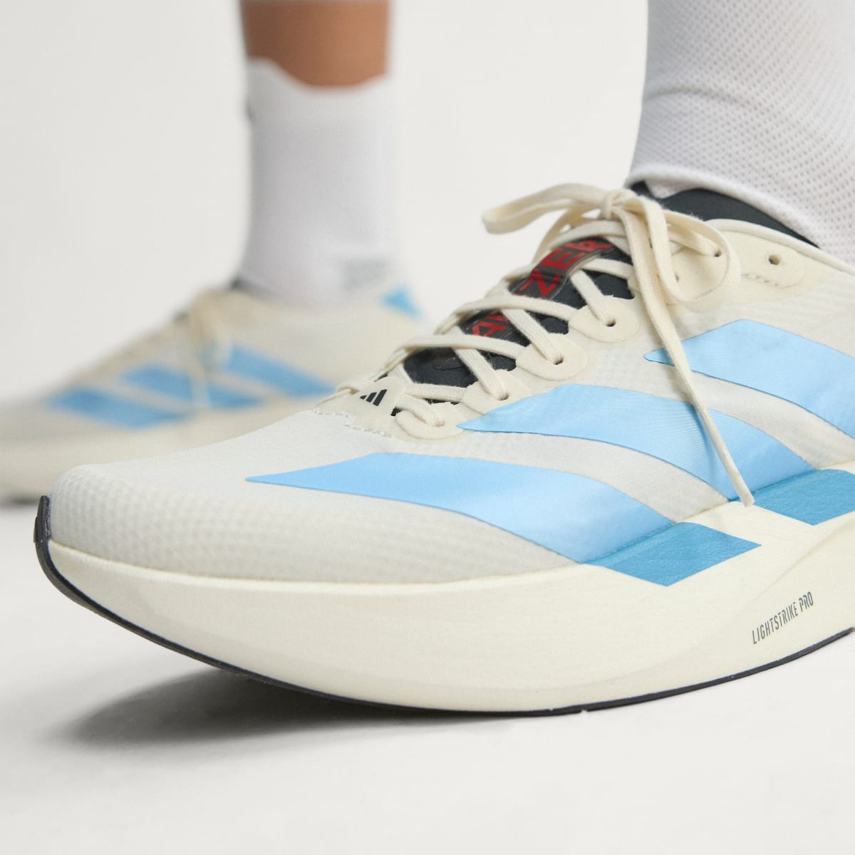 Adidas Adizero Evo SL Woven women's running shoe in Off White/Light Blue/Off White — upper and lacing detail