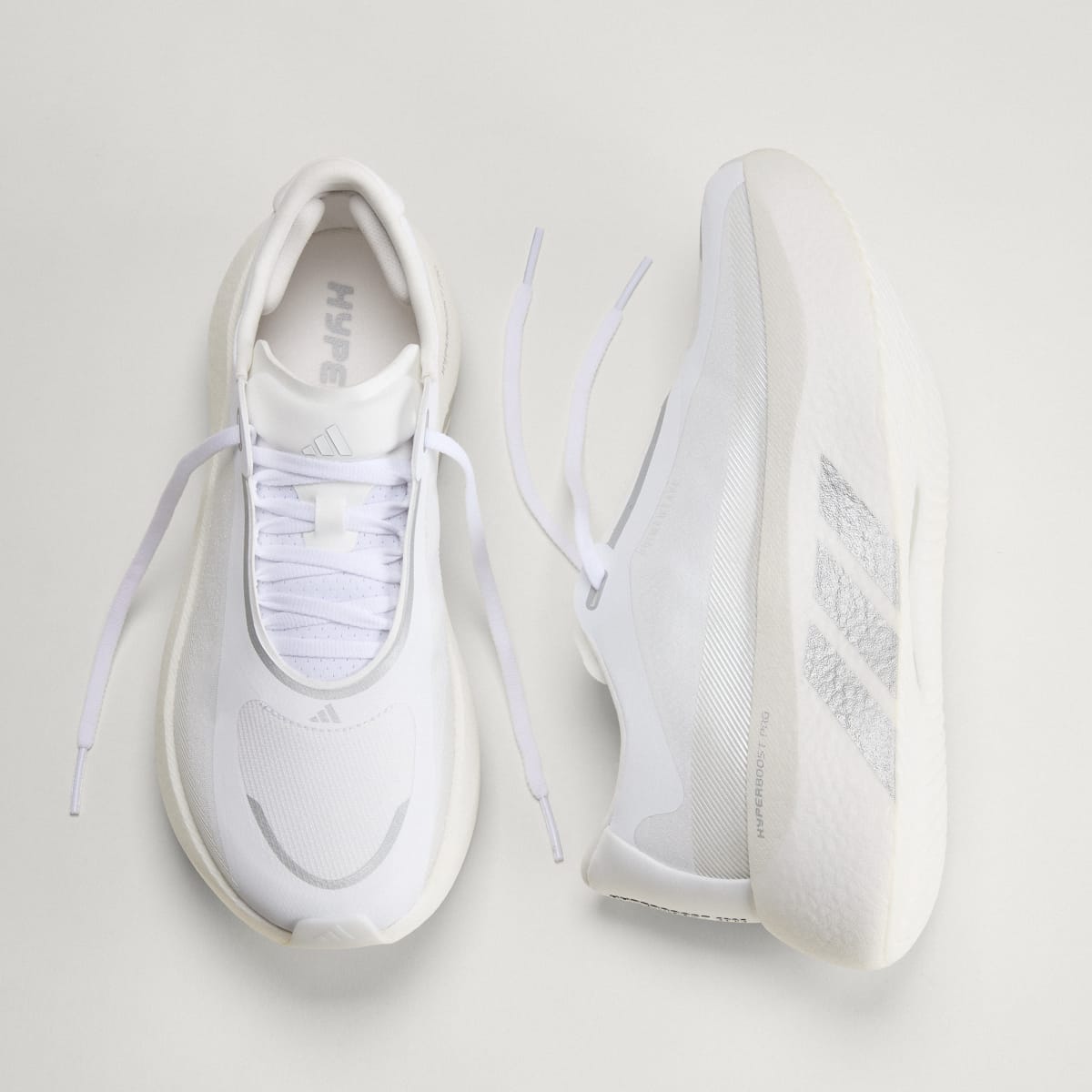 Adidas Hyperboost Edge men's running shoe in Cloud White/Silver Metallic/Zero Metallic — top and opposite side views.
