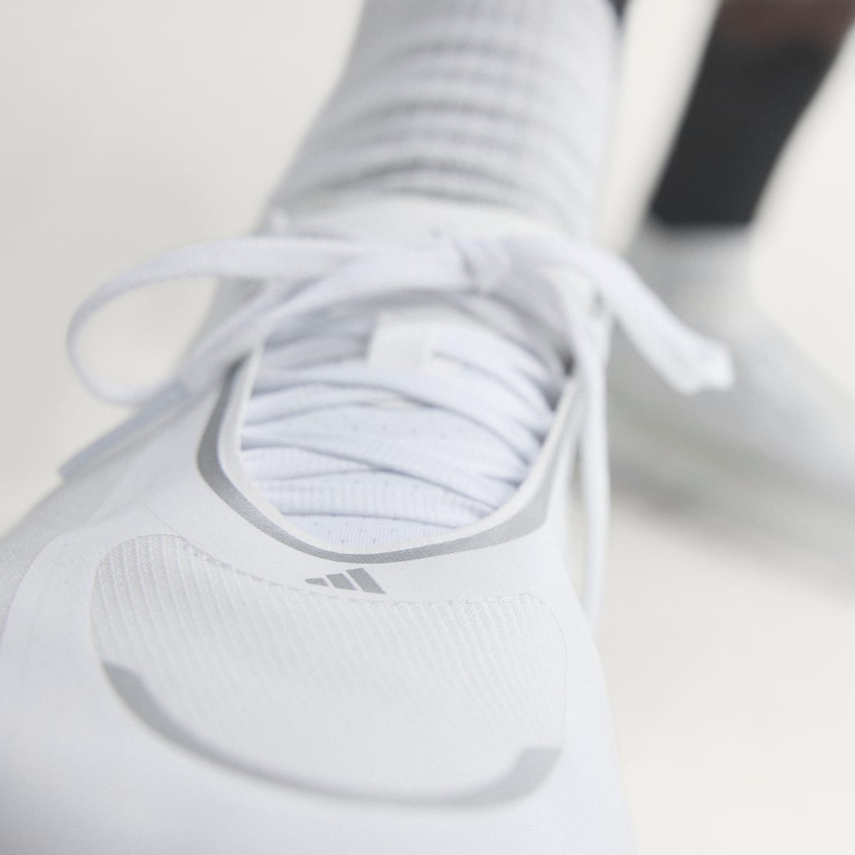 Adidas Hyperboost Edge men's running shoe in Cloud White/Silver Metallic/Zero Metallic — upper and lacing close-up.