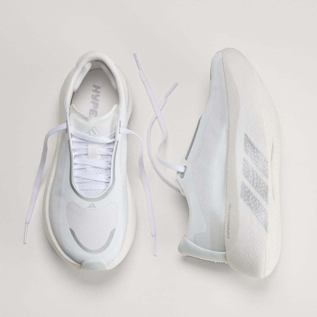 Adidas Hyperboost Edge women's running shoe in Cloud White/Silver Metallic/Zero Metalic — top and opposite side views