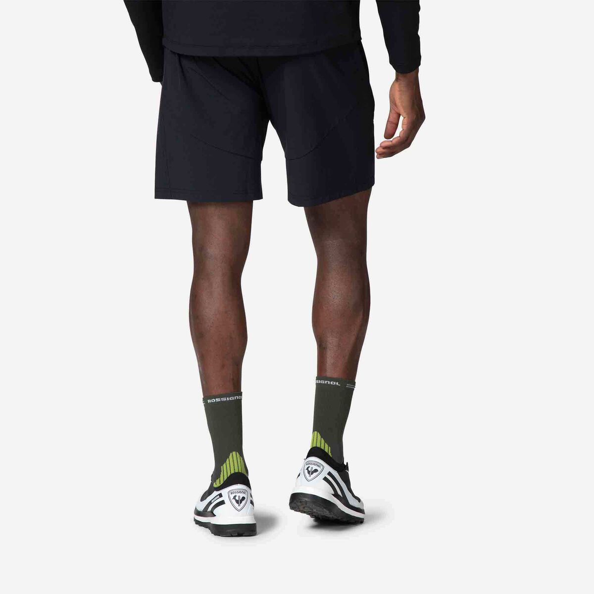 Person wearing black shorts, socks, and sneakers on a white background