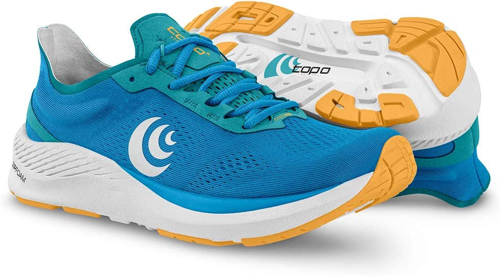 Women's Topo Athletic Cyclone. Blue upper. White midsole. Gold highlights. Lateral view.