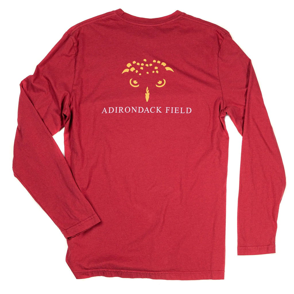 the back of a red long-sleeve tee shirt with yellow outline of an owl's face and the text "adirondack field" in the center