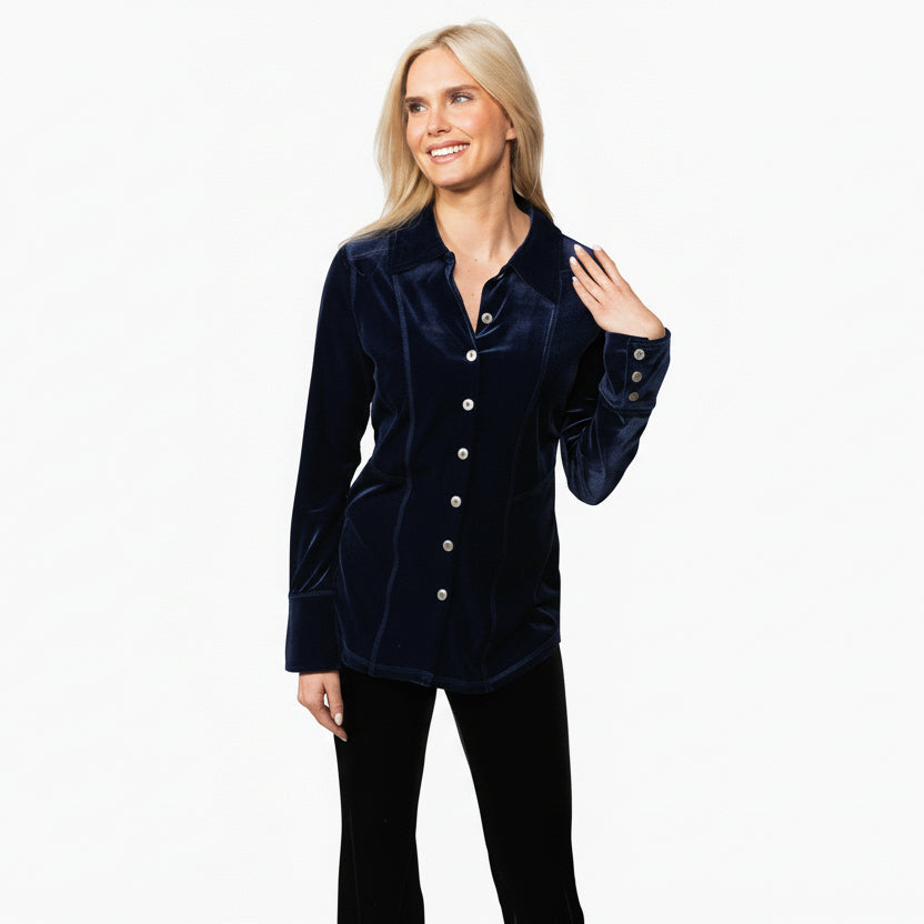 A woman modeling a navy velvet button-down shirt with metal buttons and long sleeves.