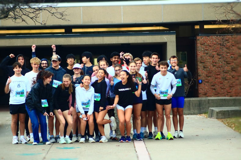 HWS 222 runners from Binghamton University crossing the half marathon finish line with smiles and medals after completing their semester-long training journey