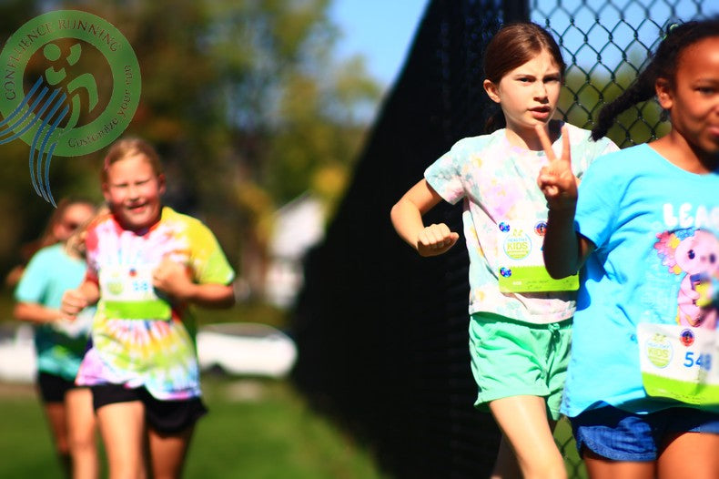 Pre-K runners sprint down the track with big smiles and cheering parents in the background.