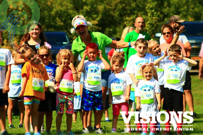 Children stretching before the race at Healthy Kids Running Series in Binghamton, NY, sponsored by Visions Federal Credit Union. A fun, family-friendly event promoting youth fitness.