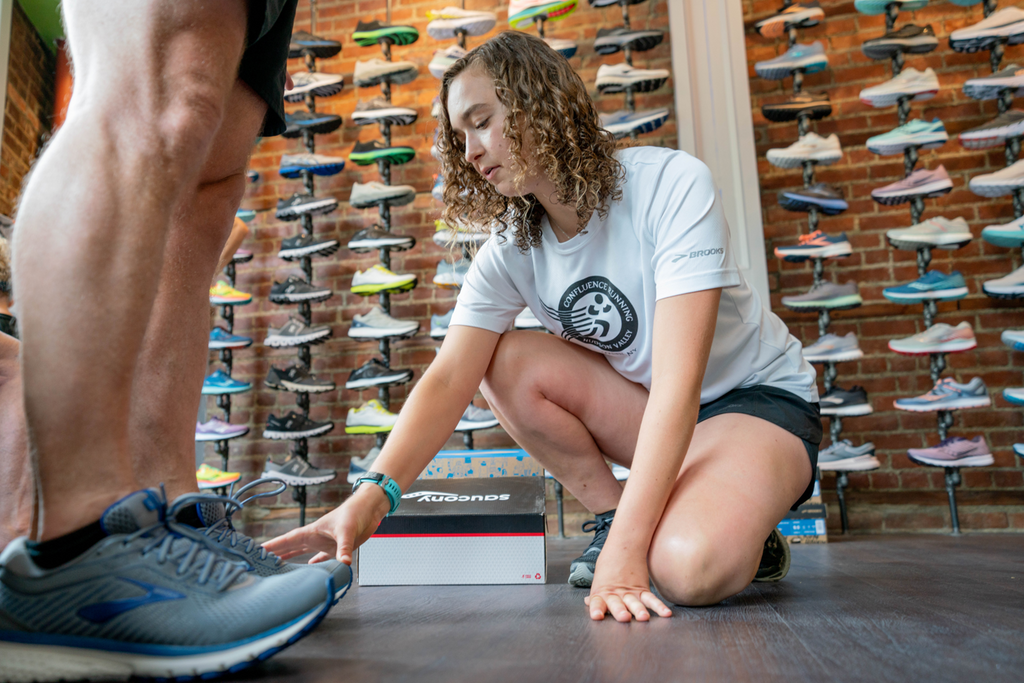 Chloe Peer fitting runner Dave Madden in running shoes in running store in Goshen, New York