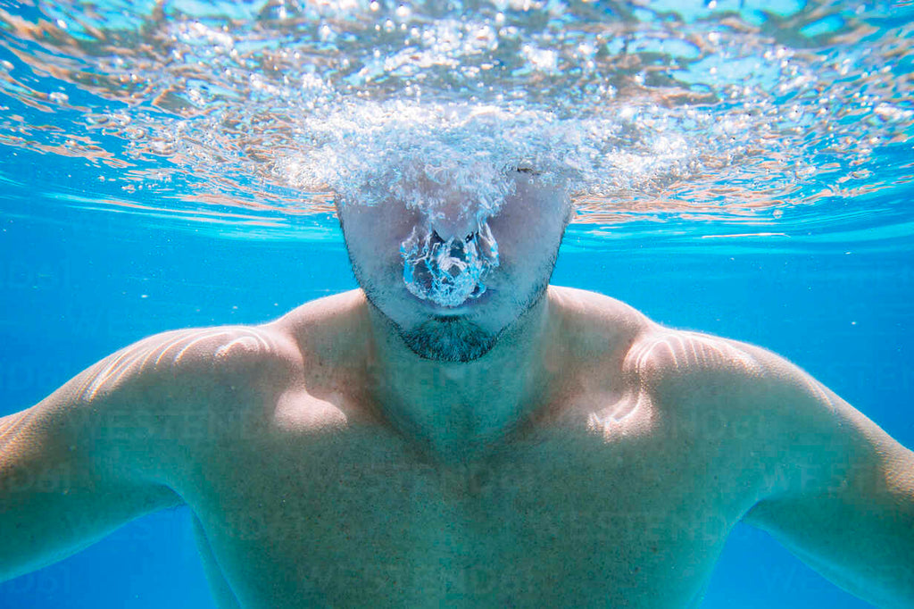 underwater-view-of-man-in-swimming-pool-blowing-bubbles-from-mouth-learn to swim binghamton university