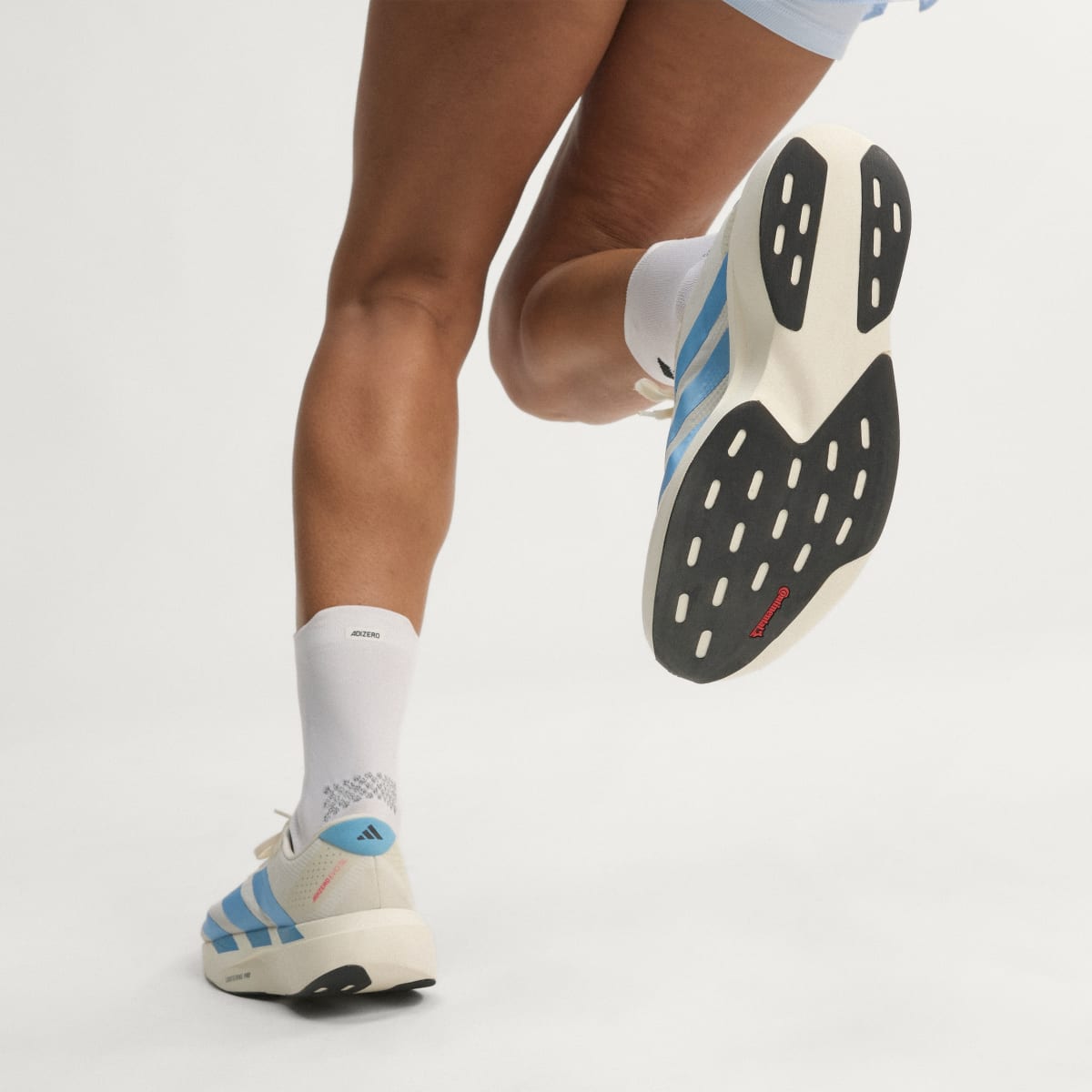 Adidas Adizero Evo SL Woven women's running shoe in Off White/Light Blue/Off White — outsole detail while running
