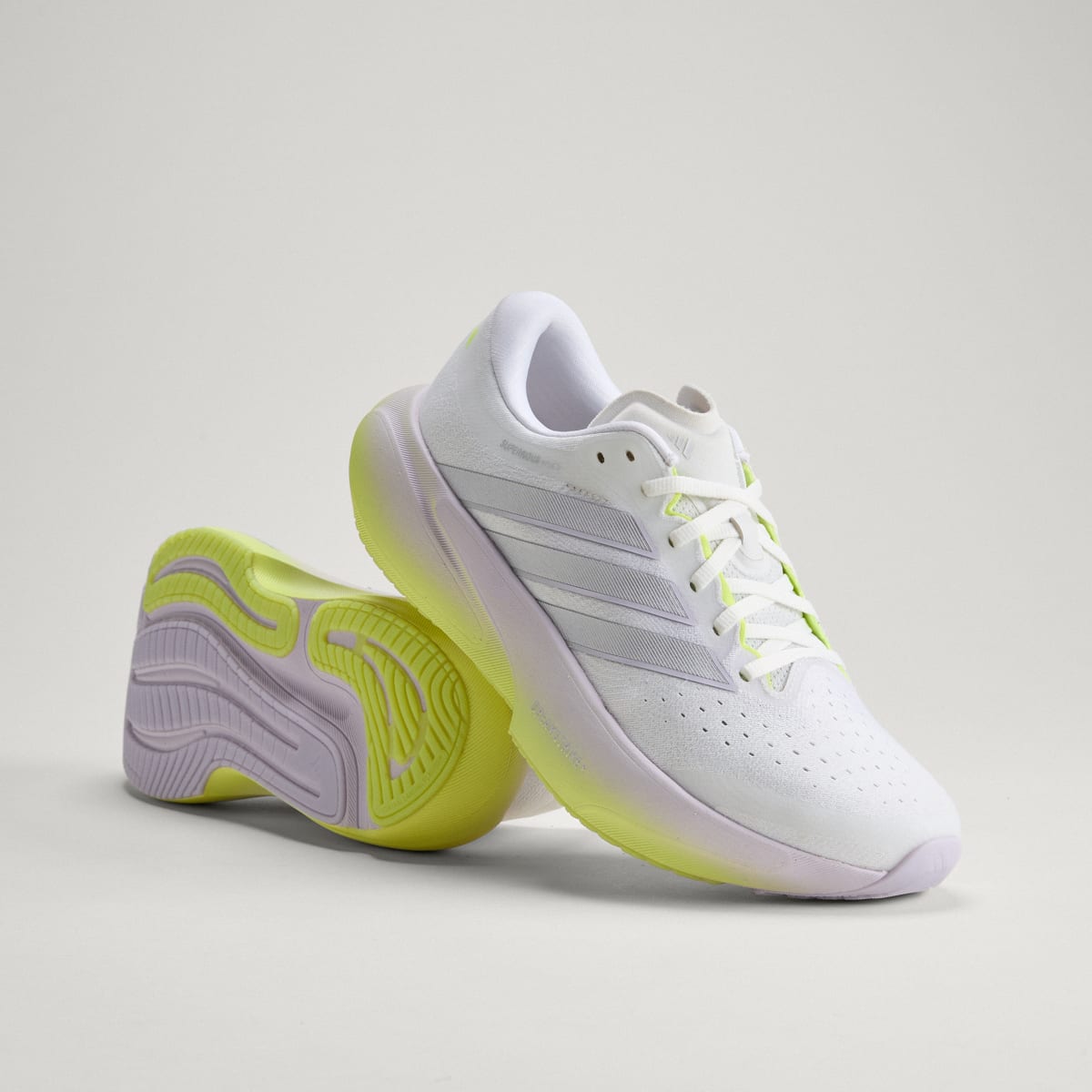 Adidas Supernova Rise 3 women's running shoe in Crystal White/Silver Metallic/Purple Tint — angled pair with outsole visible