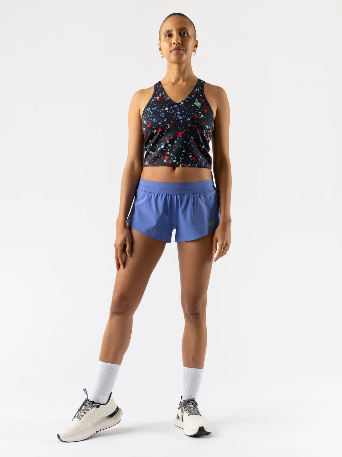 Woman wearing a patterned sports bra and blue shorts on a white background