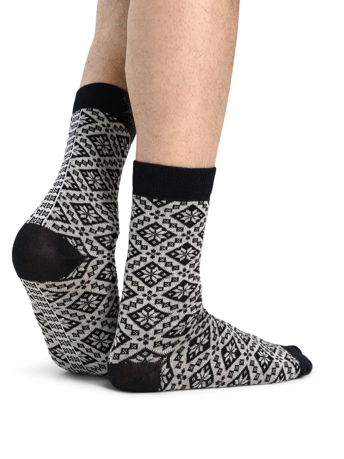Bjoroy crew socks in Black/Off White worn as a pair, showing the Nordic rose pattern