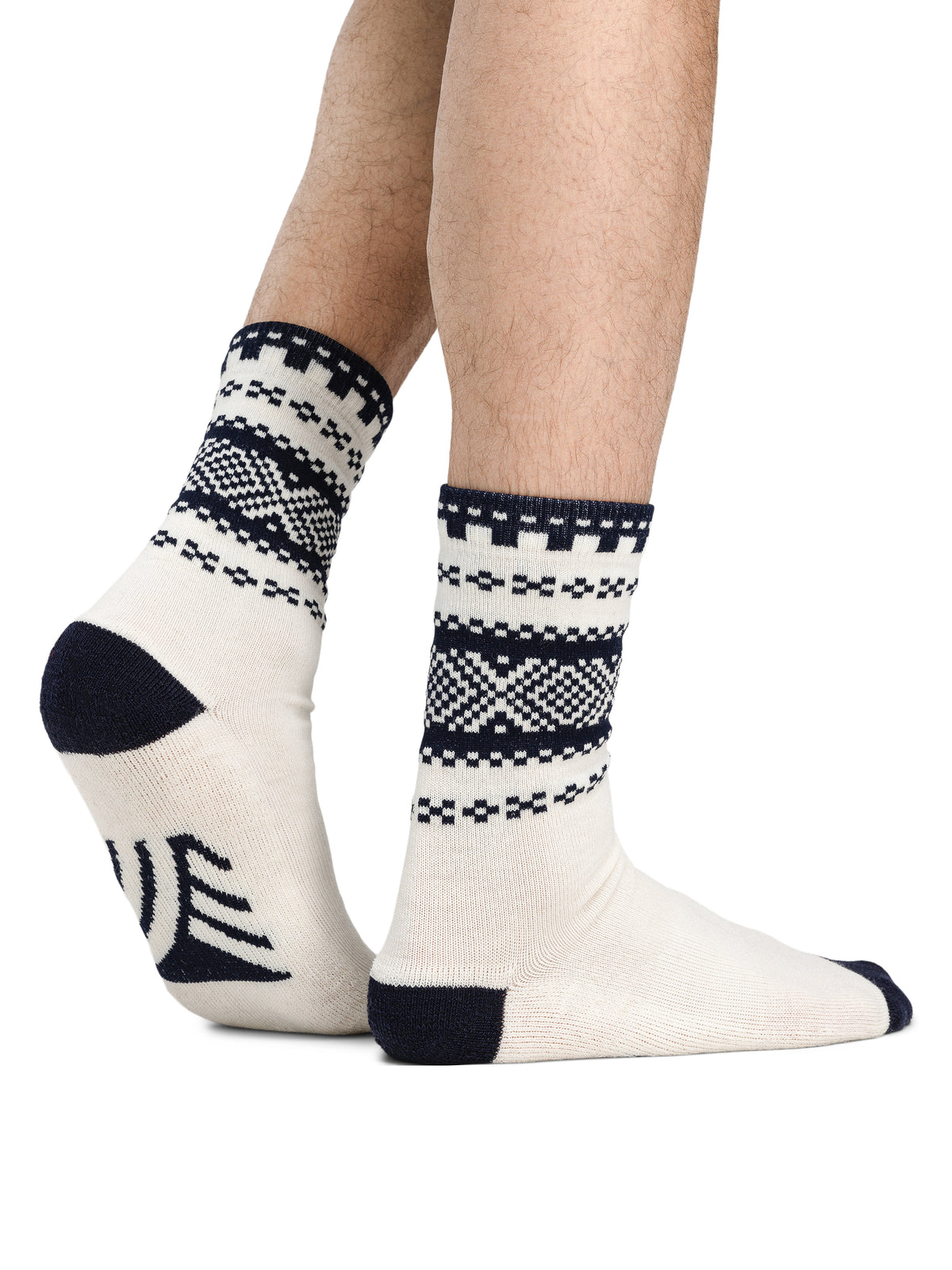 Dale of Norway Cortina unisex crew socks in off-white and navy, pair shown on feet