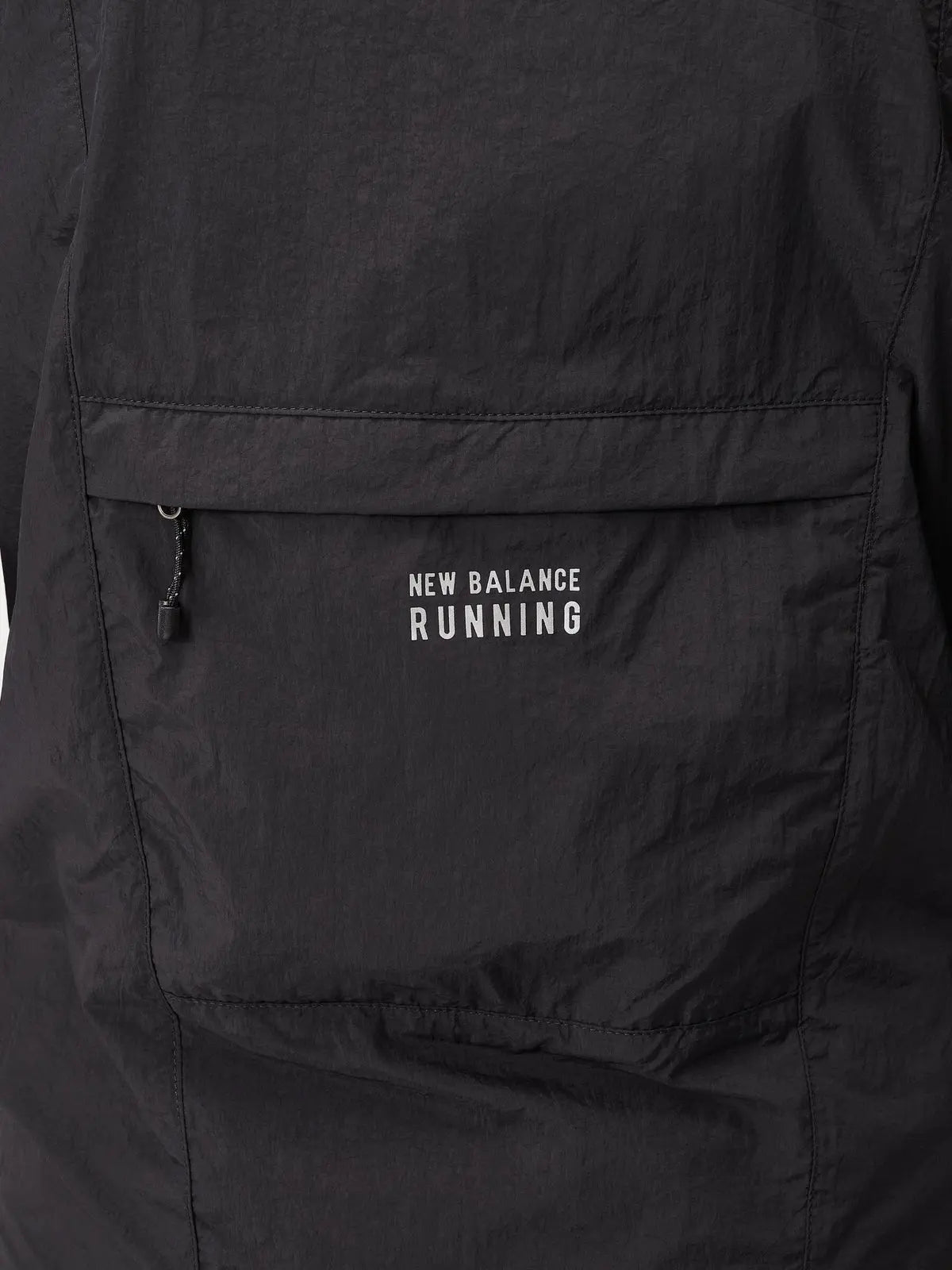 New Balance women's Impact Run Jacket in Black, packable rear pocket detail