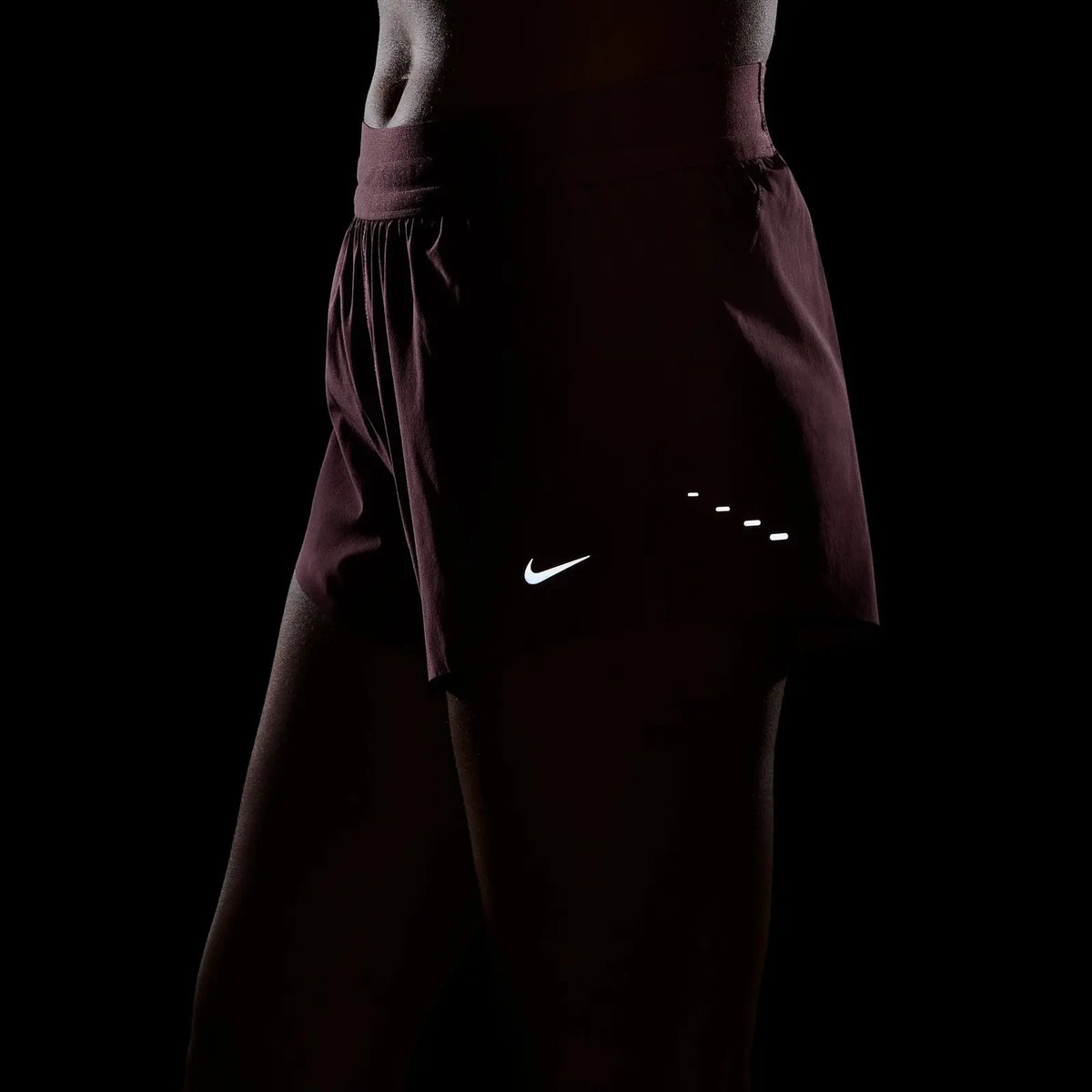 Women's Nike Dri-FIT Mid-Rise 2.5-inch Running Shorts in Pink Rise, reflective details shown in low light.