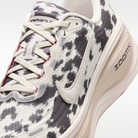 Nike Vomero Plus men's shoes in Sail/Black/University Red with animal-print upper — upper and lace detail.