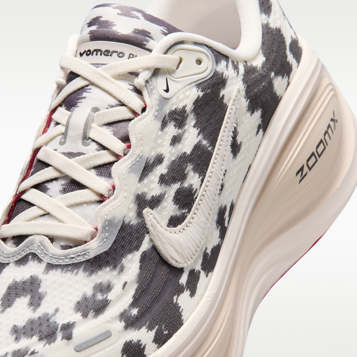 Nike Vomero Plus men's shoes in Sail/Black/University Red with animal-print upper — upper and lace detail.