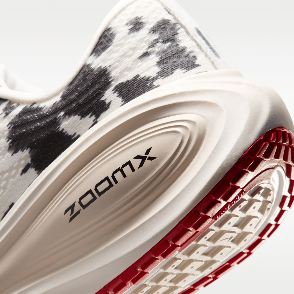 Nike Vomero Plus men's shoes in Sail/Black/University Red with animal-print upper — heel, ZoomX midsole and outsole detail.