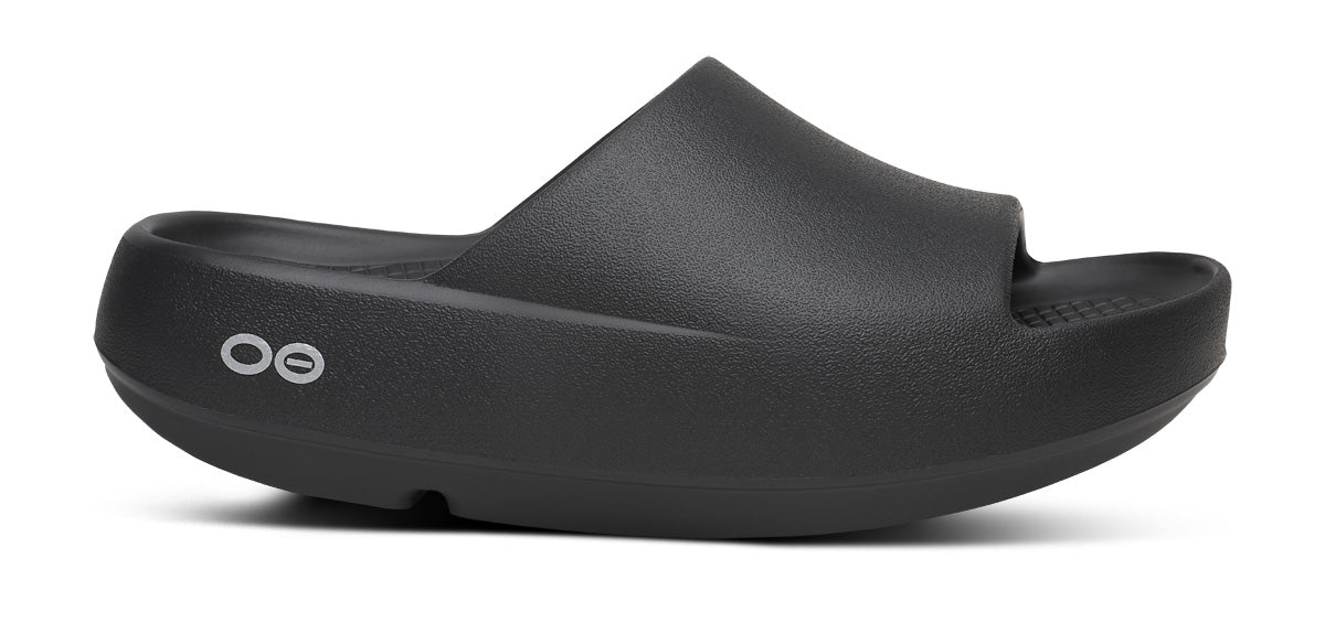 Unisex Oofos OOahh PLUS Slide in Black, lateral side view.