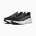 Black running shoes with white soles on a light gray background