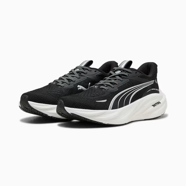 Black running shoes with white soles on a light gray background
