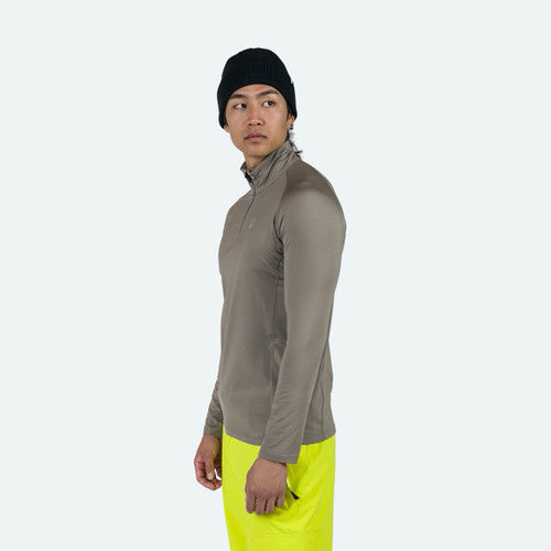 Person wearing a brown long-sleeve shirt and bright yellow pants on a white background