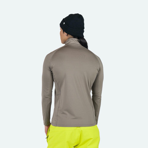 Person wearing a beige long-sleeve shirt and bright yellow pants on a white background