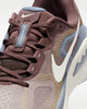 Close-up of a brown sneaker with a white swoosh logo on a white background