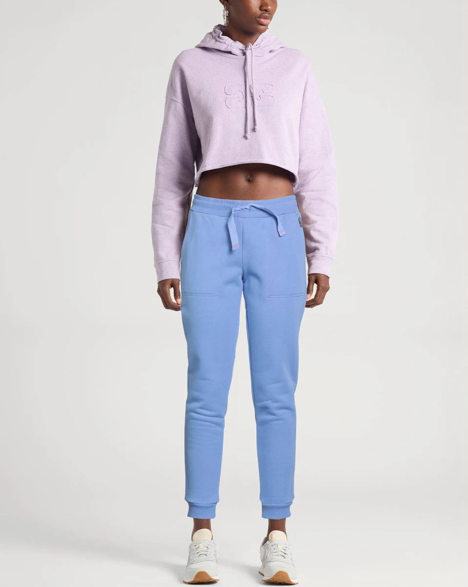 Person wearing a light purple hoodie and blue sweatpants on a white background