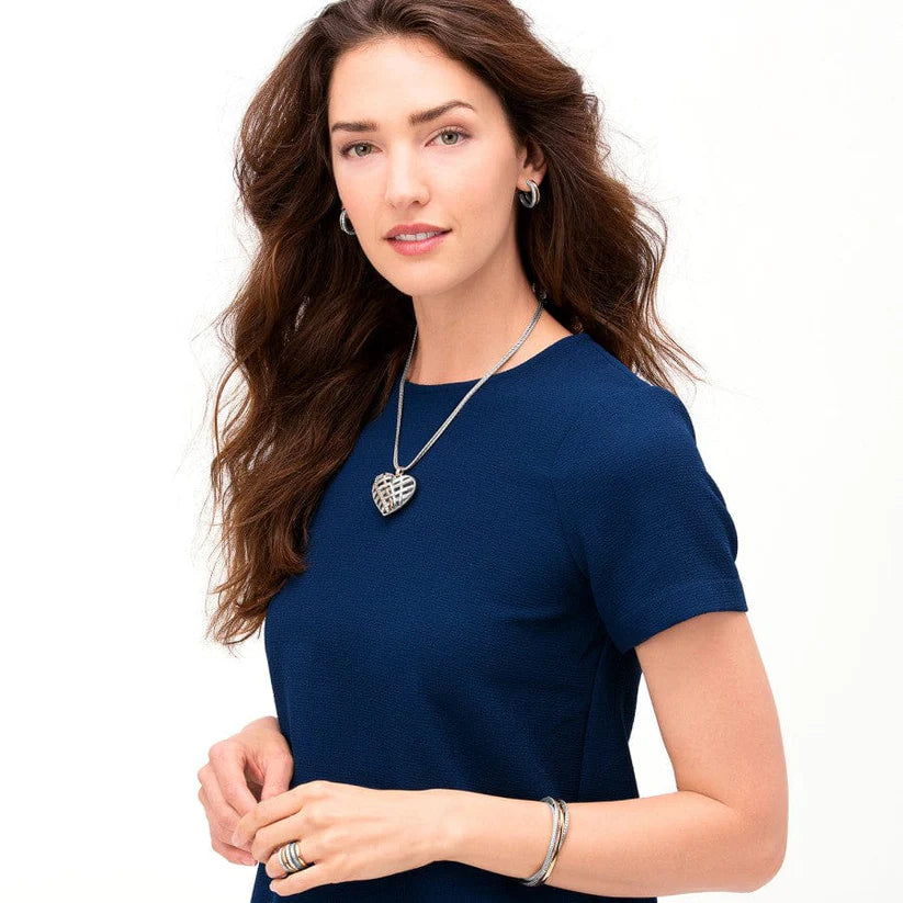 Woman wearing a blue top with a necklace on a white background