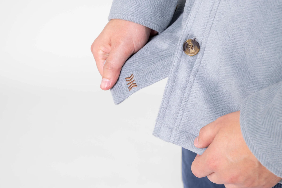 Detail of the Dakota Grizzly Rocco Silver Blue jacket hem, embroidered logo and side hand pocket