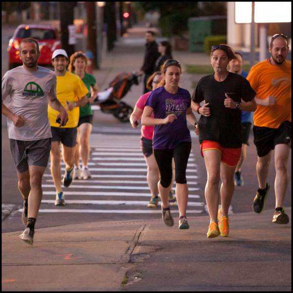 group of runners with one sticking out her tongue, and others smiling