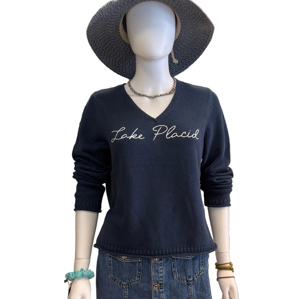 Mannequin wearing a navy blue top and denim skirt in a store setting.