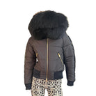 A black puffer jacket with a large black faux-fur trimmed hood, gold zippers, and black ribbed trim, shown on a mannequin against a white background.