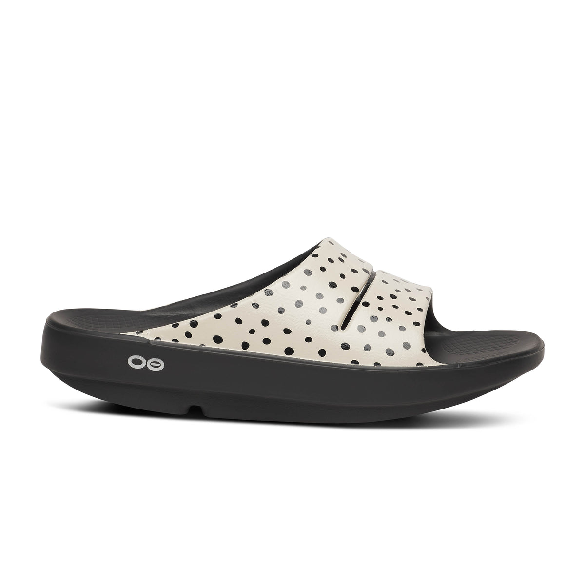 Oofos Ooahh Limited Slide. Black and tan colorway with dotted pattern. Lateral view.