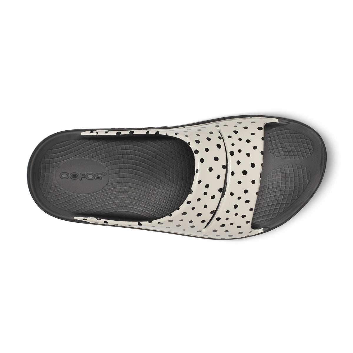 Oofos Ooahh Limited Slide. Black and tan colorway with dotted pattern. Top  view.