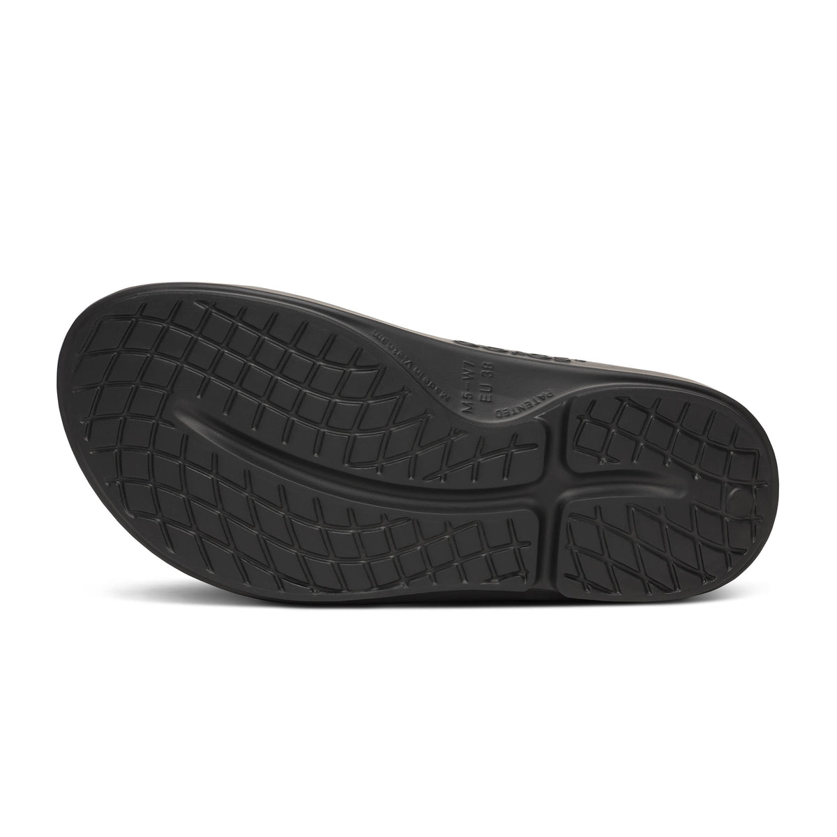 Oofos Ooahh Limited Slide. Black and tan colorway with dotted pattern. Bottom view.