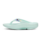 Oofos Oolala Limited Thong. Mint colorway with floral pattern. Medial view.