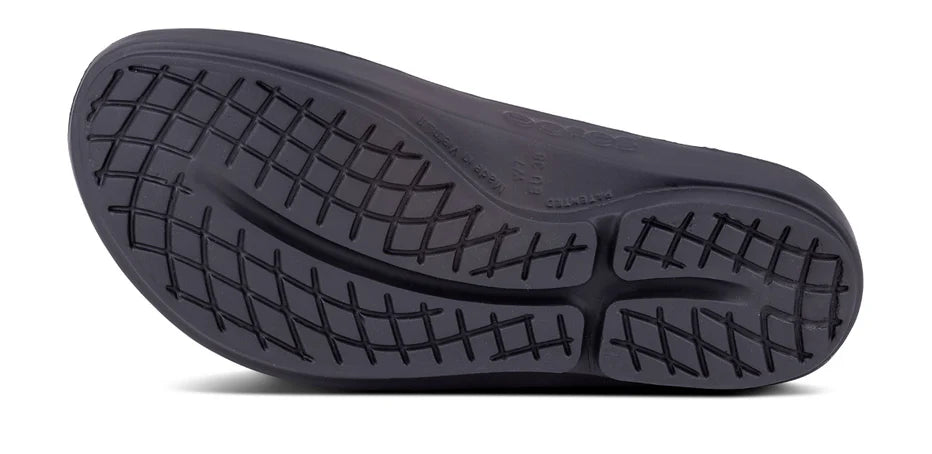 Oofos Oolala Lux Sandal. Dark Tan/Black. Bottom view.