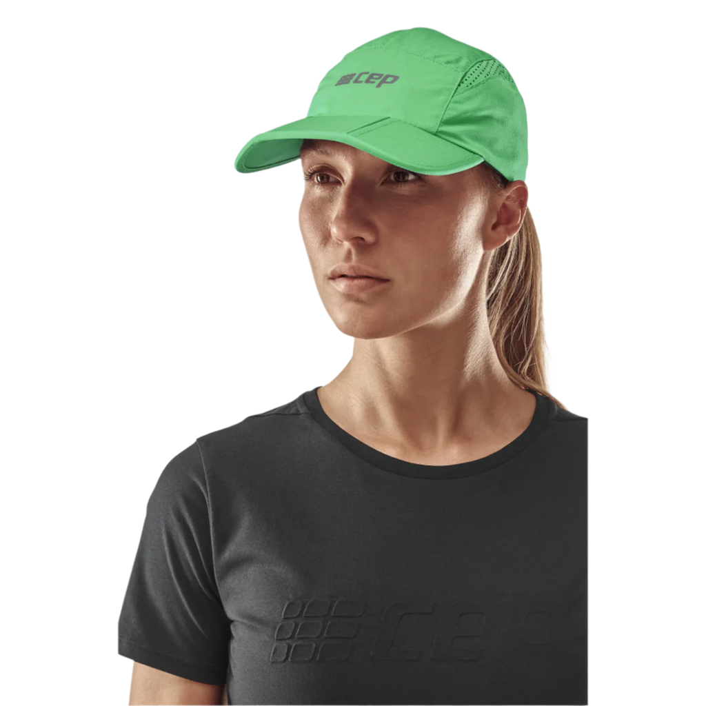 Unisex CEP Run Cap. Green. Front view on model.