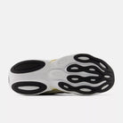 Women's New Balance Ellipse. Black, gold, and white upper. White and gold midsole. Bottom view.
