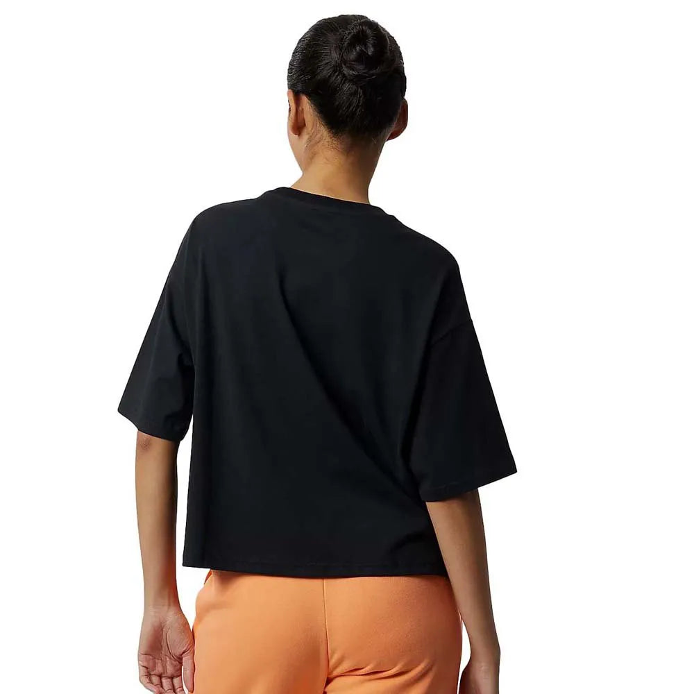 Women's New Balance Essential Bloom Tee. Black with floral pattern in the middle. Back view.