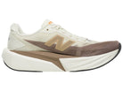 Women's New Balance Rebel v5. Off White/Tan upper. Off White/Tan midsole. Medial view.