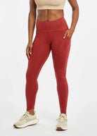 Women's Oiselle Flyout Tights in Redwood red, front view.
