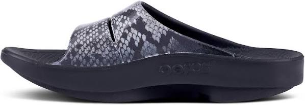 Women's Oofos OOahh Limited Slide. Grey and black snake pattern upper. Black midsole. Medial view.