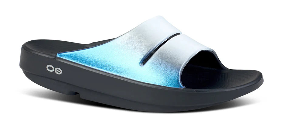 Women's Oofos Ooahh Luxe Slide. Blue Strap. Black midsole. Lateral view.