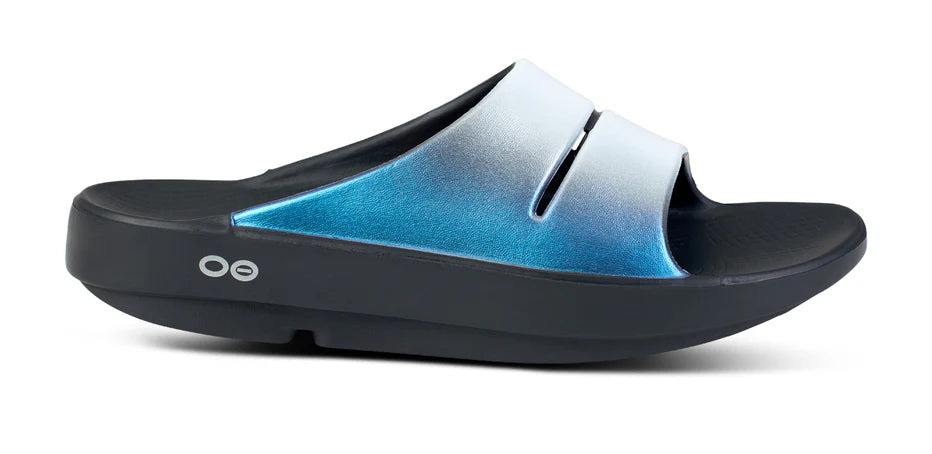 Women's Oofos Ooahh Luxe Slide. Blue Strap. Black midsole. Lateral view.