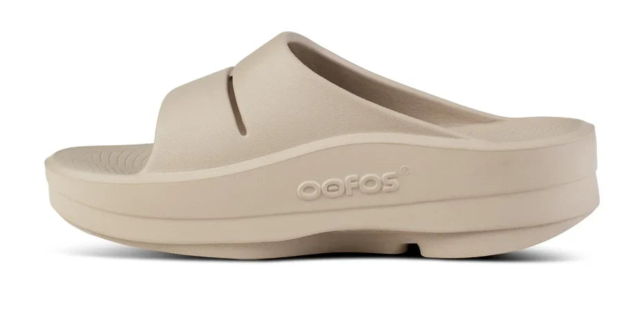 Women's OOFOS OOmega OOahh Slide in Nomad. Tan. Medial view.